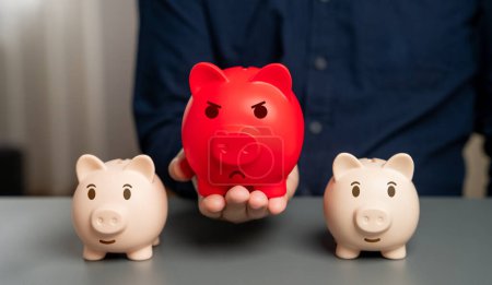 Rotes aufgeblähtes Sparschwein vor dem Hintergrund normaler Sparschweine. Überhitzter Finanzmarkt. Übersättigung der Mittel und Beschleunigung der Inflation. Schwere Belastung für den Haushalt. Schwierige wirtschaftliche Lage
