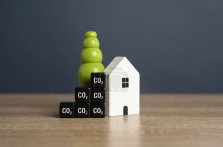 Foto de Casa y cubos métricos de CO2. Eficiencia energética. Reducir la huella de carbono de los hogares y el consumo de energía. - Imagen libre de derechos