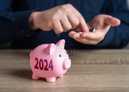 Sparschwein und 2024. Sparpläne für das kommende Jahr. Ersparnisse und Investitionen. Spendensammlung. Bankeinlagen. Sammeln Sie Geld für Ihren Traum. Reduzieren Sie die Kosten. Sparen für den Ruhestand. Geld anhäufen.