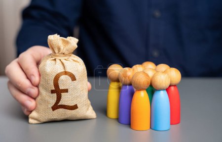 Ein Geschäftsmann hält einen britischen Pfund Sterling-Geldbeutel in der Nähe einer Gruppe von Menschen-Figuren. Vorzugsdarlehen für Unternehmer und Unternehmen. Soziale Unterstützung. Zuweisung von Haushaltsgeldern für Projekte.