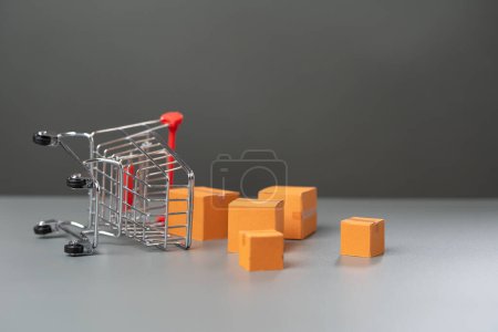 Photo for An overturned shopping cart with boxes of goods falling out. Fall in demand for goods. Decrease in purchasing power of buyers. Market research, marketing. - Royalty Free Image