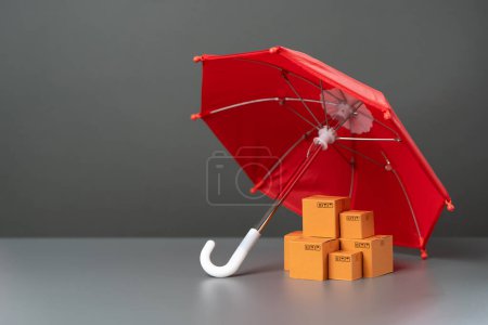 Kisten mit Waren unter einem roten Regenschirm. Fracht- und Paketversicherung. Gewährleistungspflichten. Logistische Sicherheit. Schutz des nationalen Erzeugermarktes. Verhängung von Schutzzöllen auf ausländische Konkurrenten.