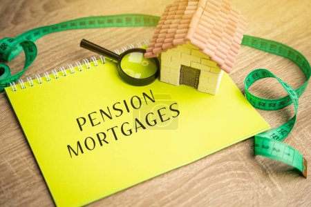 Photo for Pension mortgages concept. Buy a property through your pension fund. Real estate, business and finance concept. Notes, house and magnifying glass - Royalty Free Image