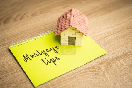 Photo for Inscription Mortgage tips in a notebook. Tips for getting a loan to buy a home. Affordable housing for young families. Real estate and finance concept - Royalty Free Image