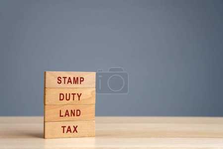 Stempelsteuer Grundsteuer SDLT Konzept. Steuern, die bei der Übertragung von Immobilien zwischen zwei Parteien anfallen. Kauf von Wohnungen und Land. Eigentum. Holzklötze