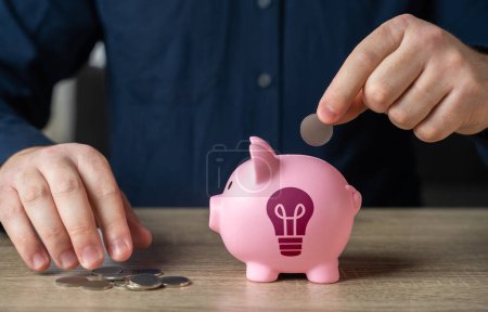 Save up for an idea. A man throws coins into a piggy bank with an idea light bulb symbol. Find investments. Encourage action. Inspire to buy. Invest in the successful launch of a startup. Patenting.