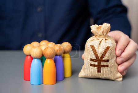 A businessman holds a japanese yen money bag near a group of people figurines. Social support. Allocation of budget money for projects. Preferential loans for entrepreneurs and businesses.