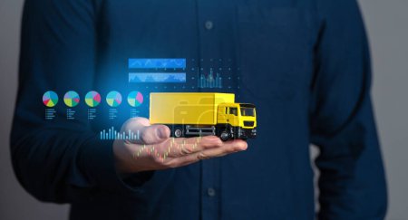 Businessman holding a truck and economic charts. Logistics industry. Transport optimization. Selection of delivery methods, effective number of vehicles and crews.