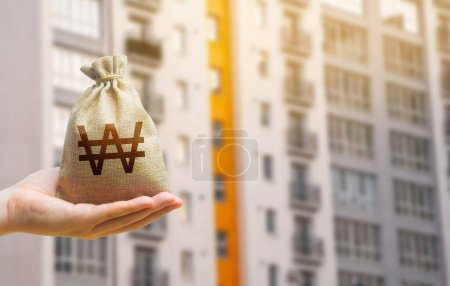 Photo for South korean won bag against the background of modern high-rise buildings. Investing in the purchase of real estate. Affordable housing and mortgage rates. Renting apartments and houses. Blurred - Royalty Free Image