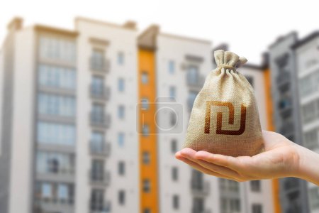 Israeli shekel bag against the background of modern high-rise buildings. Investing in the purchase of real estate. Affordable housing and mortgage rates. Renting apartments and houses. Blurred