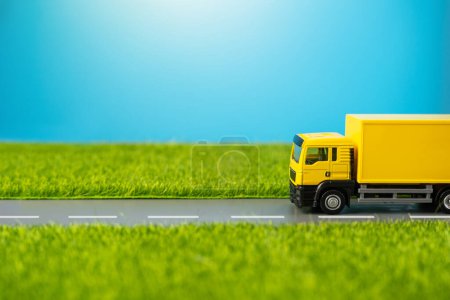 Ein Lastwagen fährt auf einer Landstraße durch grüne Wiesen. Lieferung von Online-Bestellungen und -Käufen. Lieferung von Waren. Logistik und Industrie.