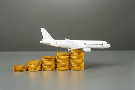 Saving on air travel. Loyalty programs and air miles, bonuses. Low cost airlines. Airplane on a growing stack of coins.