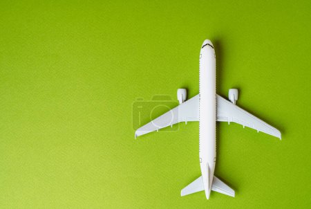 Passenger plane on a green background and space for text. Environmentally friendly fuel. Technological innovations in aviation industry. Green air transportation