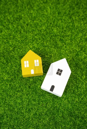 Figuren von Häusern auf einem Hintergrund aus Gras. Ein Haus kaufen. Hypothekendarlehen. Bezahlbarer Wohnraum. Wohnungssuche und Maklerservice