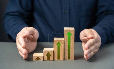Protect growth and development. A businessman covers a growth graph with his hands. Successful investments. Income and economic development. Optimistic forecast. Entrepreneurship.