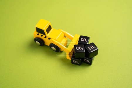 Photo for A bulldozer drags cubes of CO2. Greenhouse gas emissions from industry. New rules and directives, restrictions on the impact on the environment. Carbon taxes. Closed waste-free production cycle. - Royalty Free Image