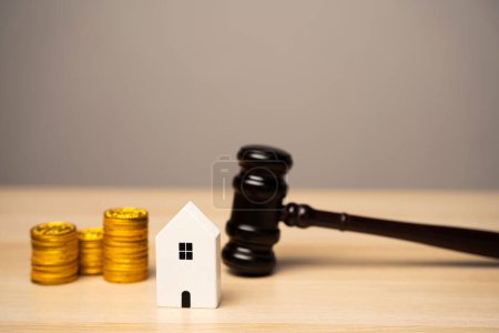 Richterhammer und Haus mit Münzen. Immobilien- und Rechtsschutzkonzept. Verteilung des Eigentums. Wohnungsversteigerung