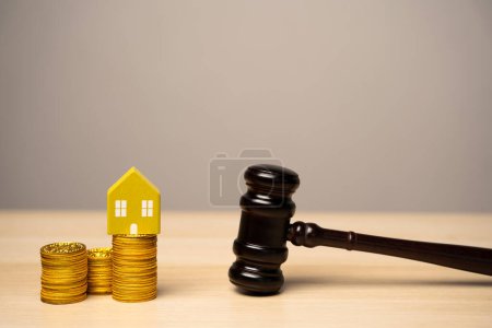 Richterhammer und Haus mit Münzen. Immobilien- und Rechtsschutzkonzept. Verteilung des Eigentums. Wohnungsversteigerung