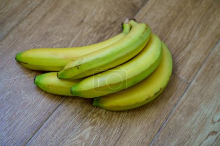 Téléchargez les photos : Image en gros plan de banane jaune mûre sur fond bois. - en image libre de droit