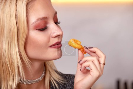 Foto de A woman with her hands eats a large appetizing shrimp. Selective focus - Imagen libre de derechos