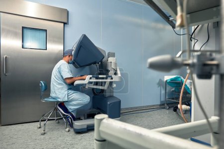 Foto de El cirujano en la cabina de control del robot cirujanos. Cirugía robótica en el momento del control de la máquina por el cirujano. - Imagen libre de derechos