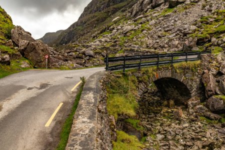 Téléchargez les photos : Pont rocheux, Route et montagnes à Gap of Dunloe avec rochers et végétation, Killarney, Kerry, Irlande - en image libre de droit