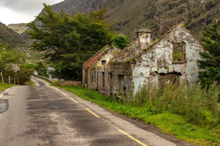 Téléchargez les photos : Maisons abandonnées, Route et montagnes à Gap of Dunloe avec rochers et végétation, Killarney, Kerry, Irlande - en image libre de droit