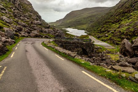 Téléchargez les photos : Pont rocheux, Route et montagnes à Gap of Dunloe avec rochers et végétation, Killarney, Kerry, Irlande - en image libre de droit