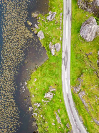 Téléchargez les photos : Vue aérienne de la route et du lac à Gap of Dunloe avec rochers et végétation, Killarney, Kerry, Irlande - en image libre de droit