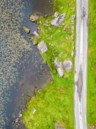 Téléchargez les photos : Vue aérienne de la route et du lac à Gap of Dunloe avec rochers et végétation, Killarney, Kerry, Irlande - en image libre de droit