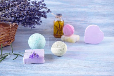 Lavender soap, fragrance oil, foam bombs and fresh lavender flowers on a wooden background, bath products
