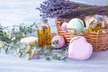 Lavendelseife, Duftöl, Schaumstoffbomben und frische Lavendelblüten auf Holzgrund, Badeprodukte