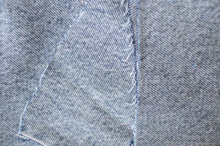 Hellblaue Denim-Textur oder Denim-Hintergrund mit Faden, textilem Material