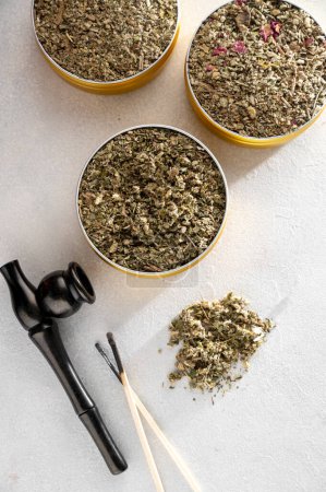 Foto de Alternativa libre de tabaco, mezclas de hierbas y flores con pipa de madera humeante, mezclas de hierbas humeantes. Vista superior - Imagen libre de derechos