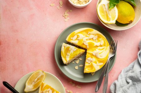Téléchargez les photos : Lemon cheesecake tart or pie, with fresh lemons. Pink background. - en image libre de droit