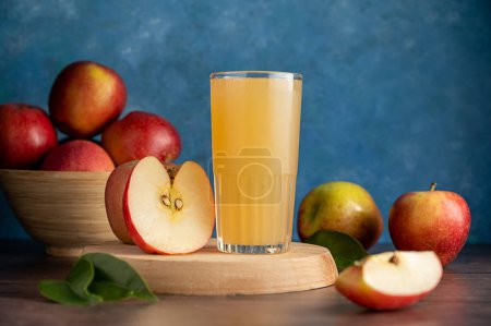 Apple juice drink with fresh red apples, wooden background. Copy space.