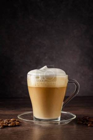 Tazas de bebida de café, latte o moca con espuma de leche. Taza de vidrio, fondo de madera oscura.