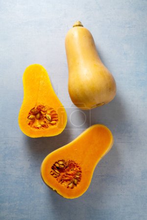 Photo for Butternut squash pumpkins on blue background. - Royalty Free Image