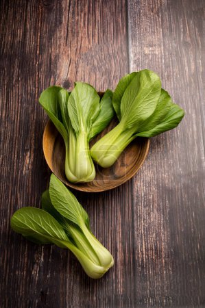 Photo for Celery cabbage or peach choi, asian baby salad leaves on wooden background, top view - Royalty Free Image
