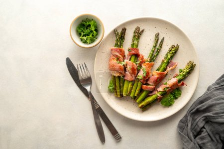 Wrapped asparagus with bacon in a plate. Top view.