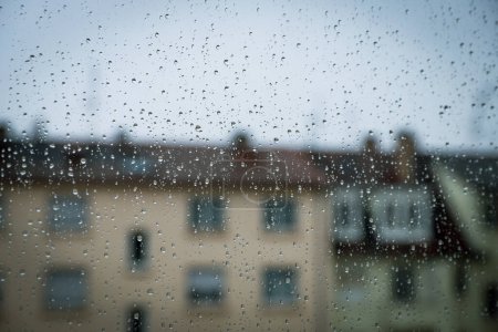 Regentropfen auf einem Fensterglas, Konzept von Regenwetter