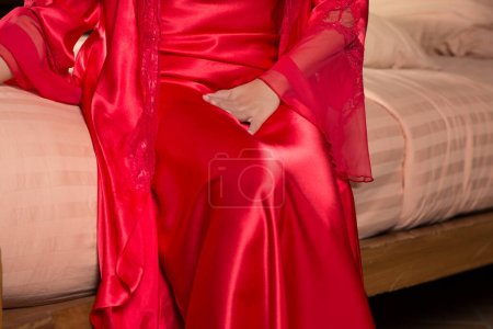 Photo for A woman in a red satin nightgown urinating frequently at night. - Royalty Free Image