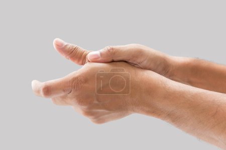Téléchargez les photos : A man with thumb pain on a gray background. - en image libre de droit