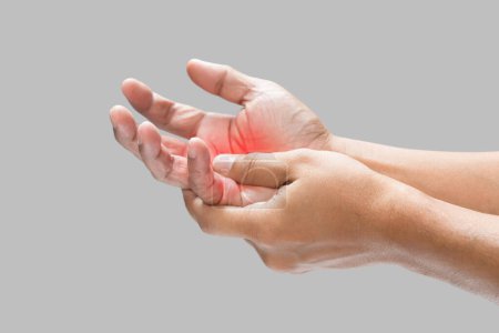 Schmerzen in der Handfläche durch Blutergüsse oder Verletzungen, isoliert auf einem grauen Wandhintergrund.