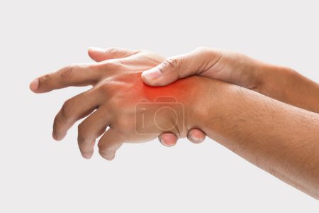 Foto de A man grab hand palm because the hand palm was injured. Hand pain. On a gray background. - Imagen libre de derechos