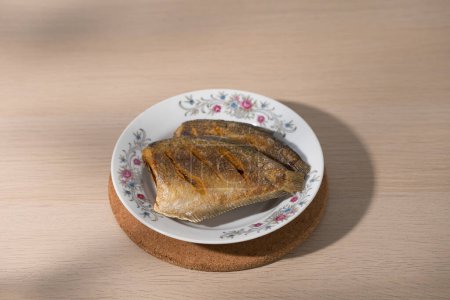 Photo for Fried gourami fish with Thai-style rice on a white plate with flower pattern. - Royalty Free Image