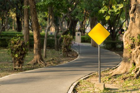 Téléchargez les photos : Panneau métallique jaune vide au bord de la route pour courir dans le parc public. - en image libre de droit