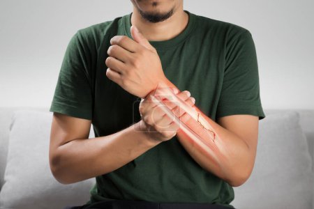 Photo for A man is in pain because of a broken forearm bone - Royalty Free Image