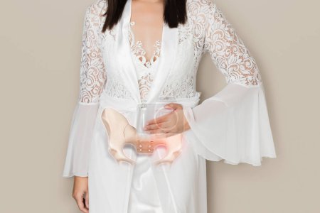 A Woman in a white satin nightgown has waist pain because the pelvis has a problem.