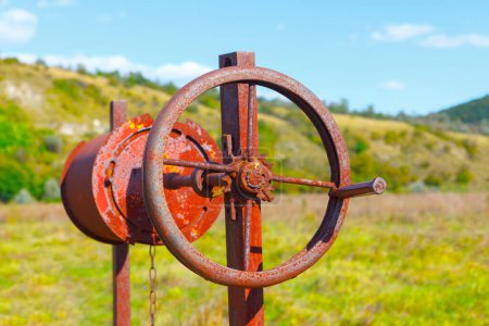 Photo for Rusty well mechanism with chain for extracting underground water - Royalty Free Image